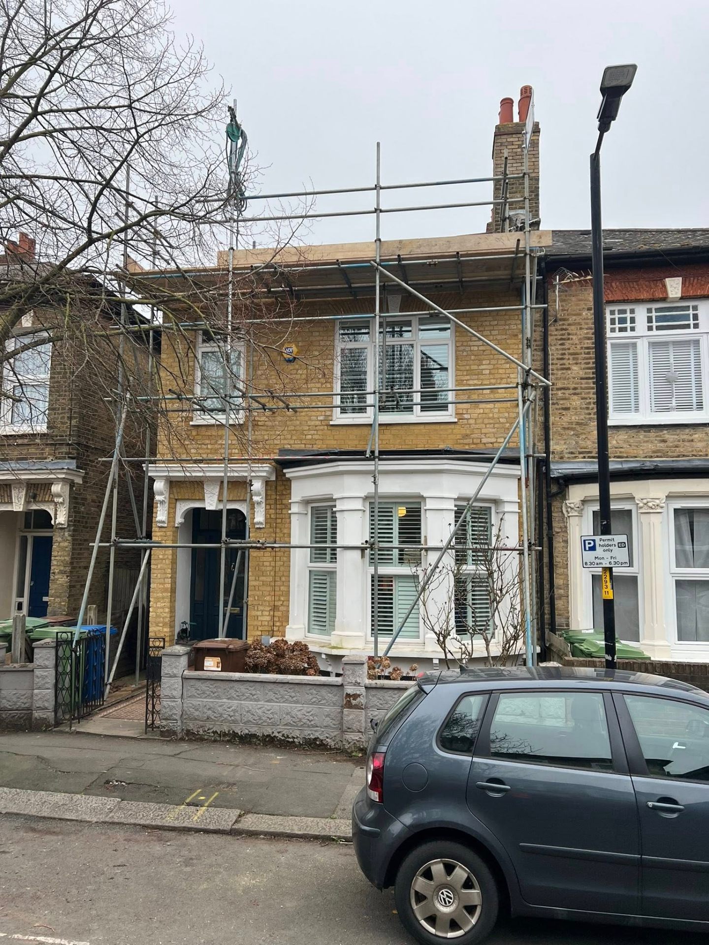 Single-lift scaffold to the front of a yellow-brick terrace